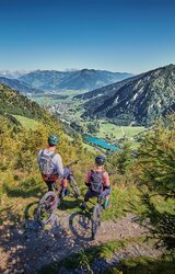 Mountain biker with a view of the green landscape and mountain panorama on the Kitzsteinhorn